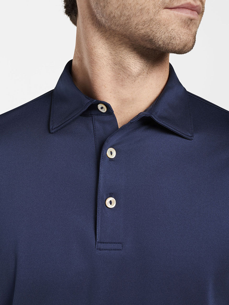 A man wearing the Peter Millar Solid Stretch Jersey Long Sleeve Polo in Navy.