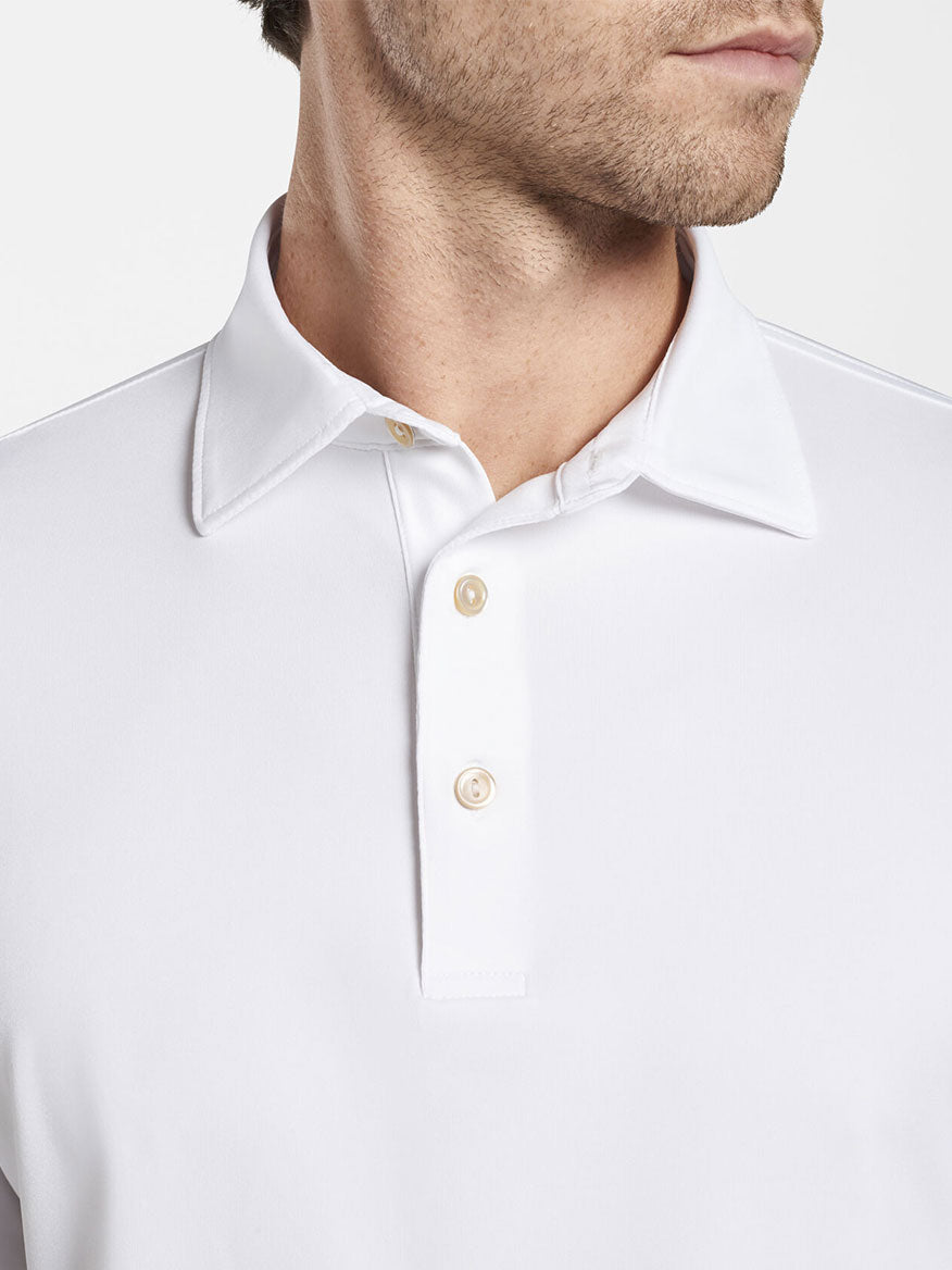A man wearing a Peter Millar Solid Long-Sleeve Performance Jersey Polo in White.