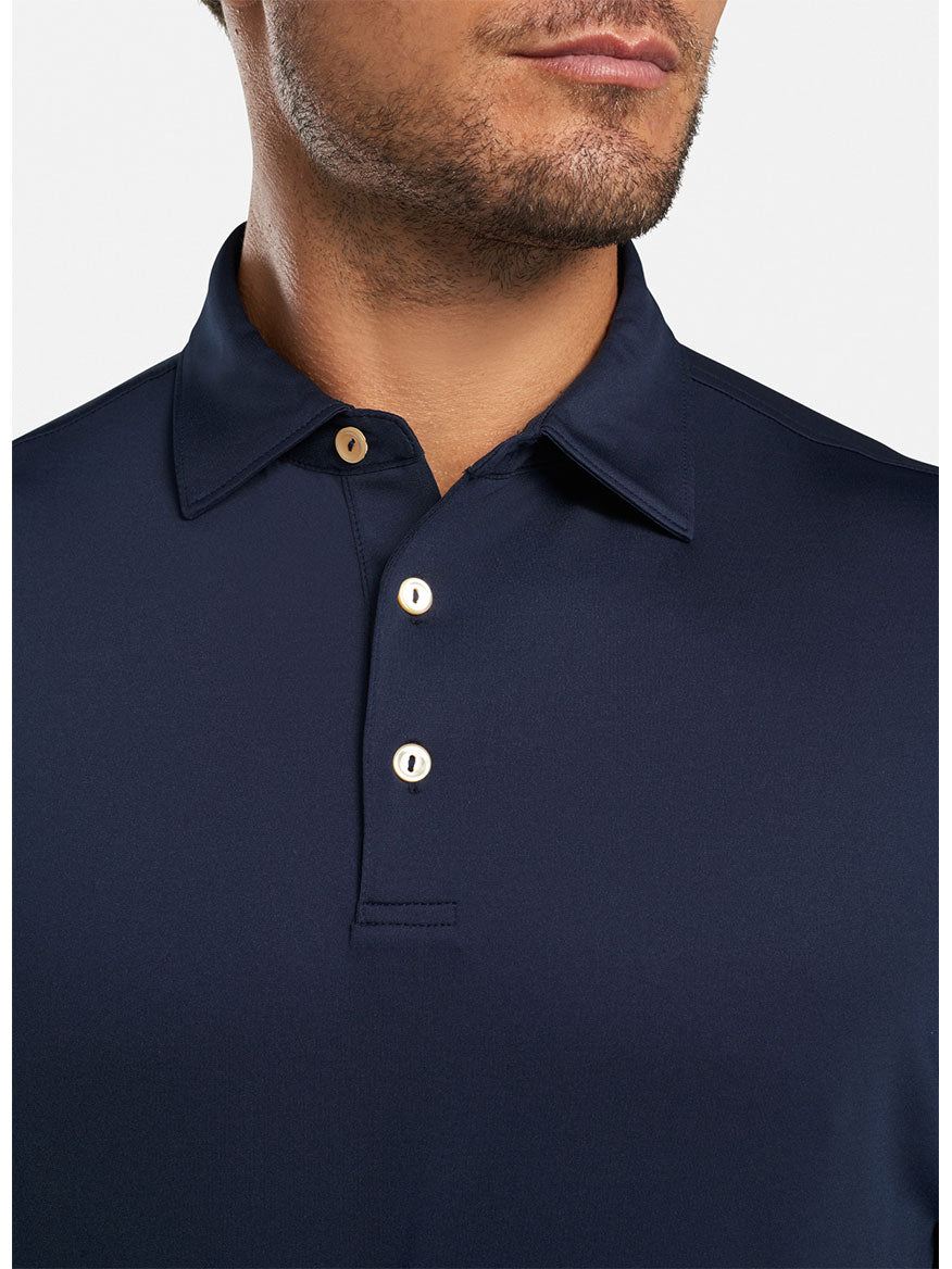 A man wearing a Peter Millar Solid Performance Jersey Polo in Navy.