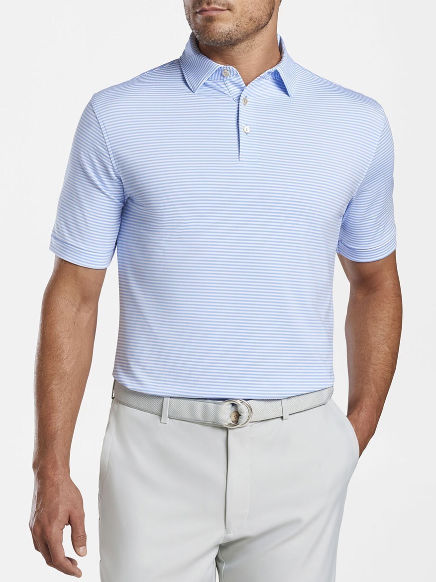 A man wearing a Peter Millar Hales Performance Jersey Polo in Cottage Blue and light gray pants.