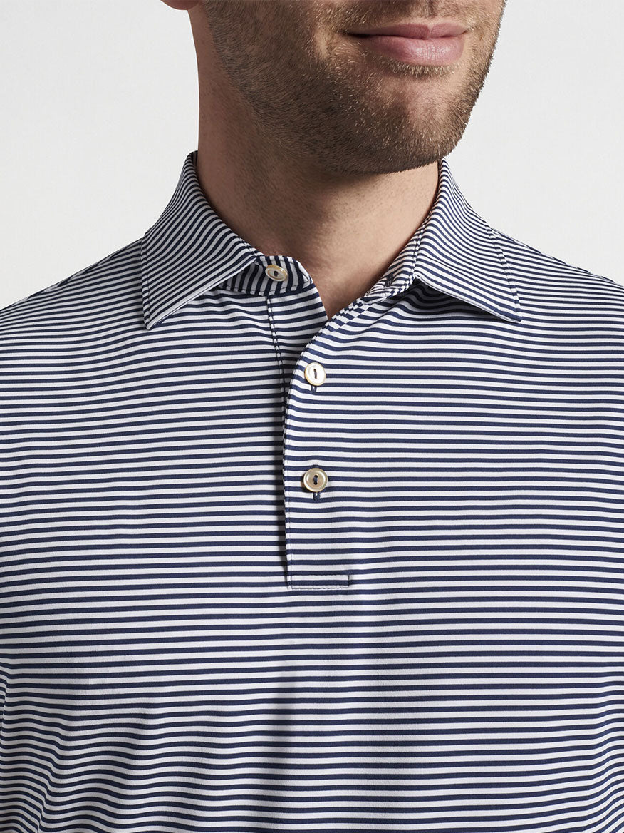 Close-up of a man wearing a Peter Millar Hales Performance Jersey Polo in Navy with UPF 50+ sun protection.
