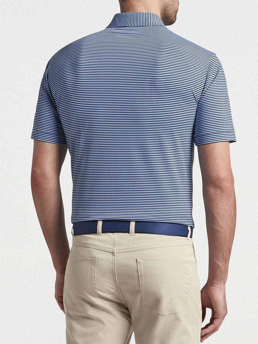A man wearing a Peter Millar Hales Performance Jersey Polo in Navy/Cottage Blue and khaki pants seen from the back.