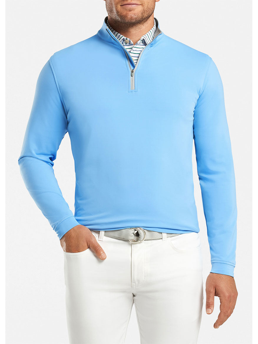 Man wearing a Peter Millar Perth Performance Quarter-Zip in Cottage Blue with white pants.