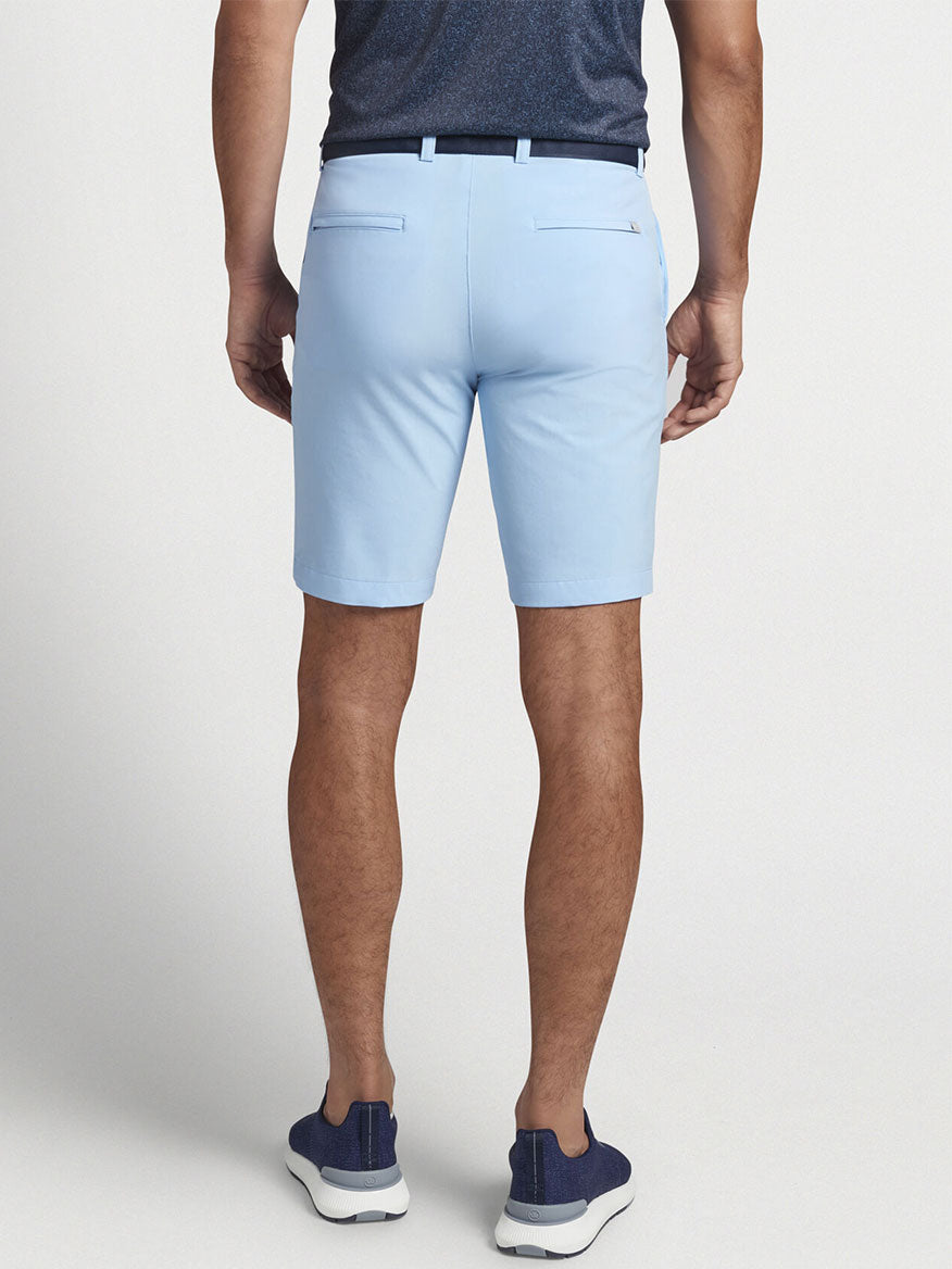 A man wearing the Peter Millar Shackleford Performance Hybrid Short in Cottage Blue that offers both mobility and performance fabric.