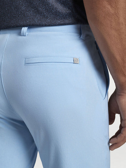The back view of a man wearing the Peter Millar Shackleford Performance Hybrid Short in Cottage Blue for enhanced mobility.