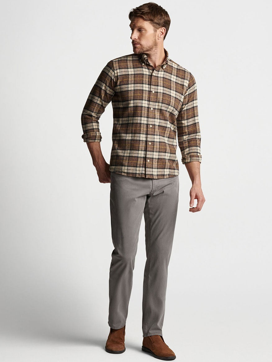 Man wearing a plaid shirt and Peter Millar Wayfare Five-Pocket Pant in Nickel standing against a neutral background.
