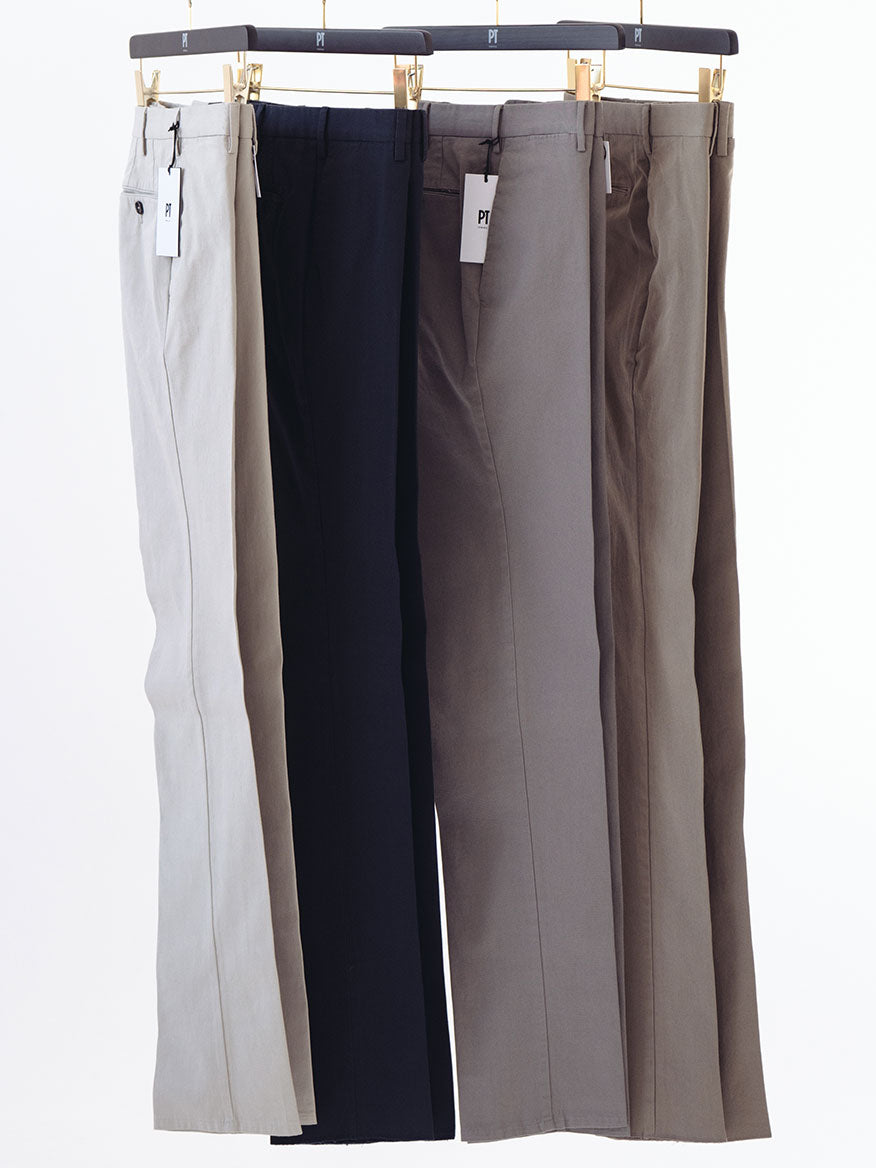 Five pairs of PT01 Dressy Stretch Canvas Trousers in Dark Grey hanging on a hanger, made from stretch cotton.