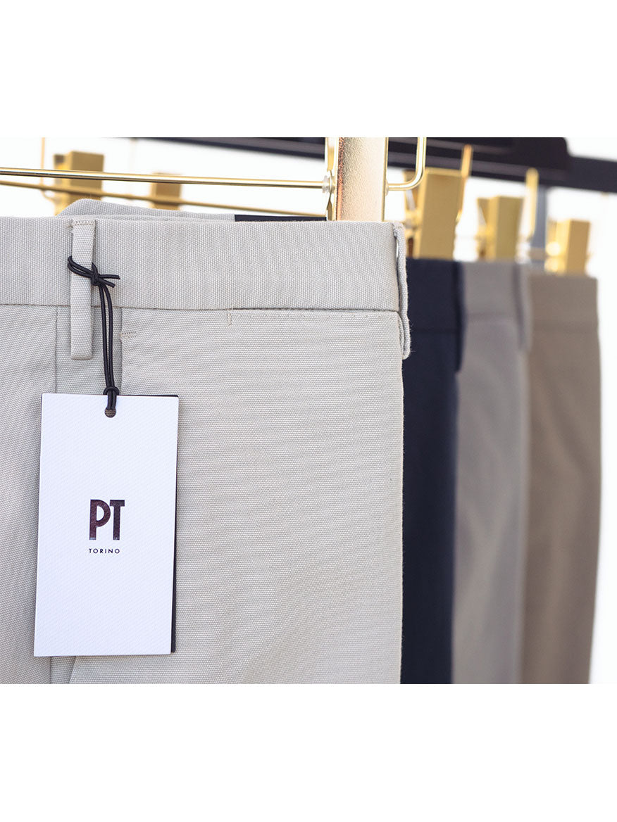 A pair of PT01 Dressy Stretch Canvas Trousers in Dark Grey hanging on a rack with a tag.