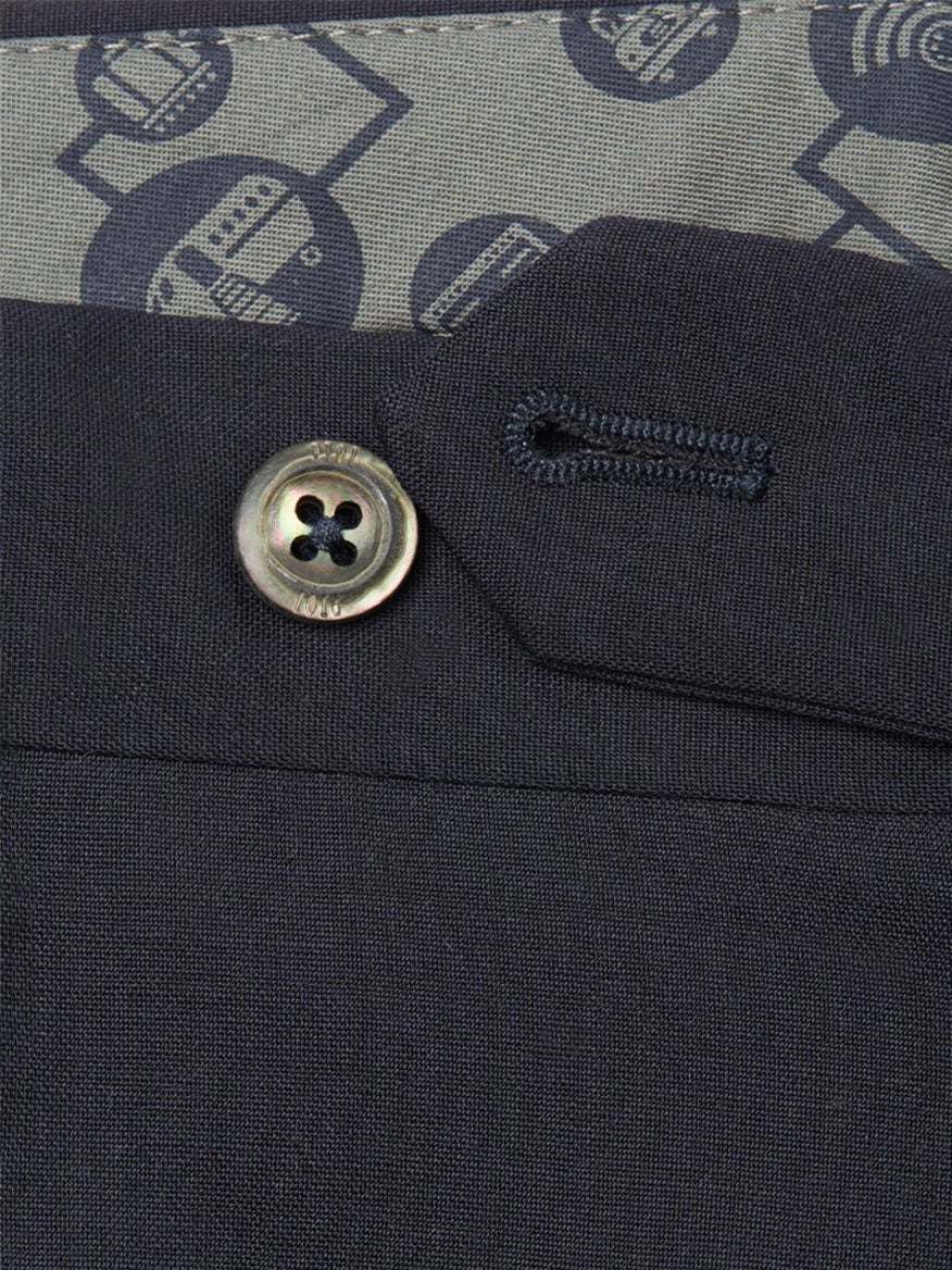 A close up of a button on a dark blue suit with PT01 Travel Wool Performance Trousers in Charcoal Grey.
