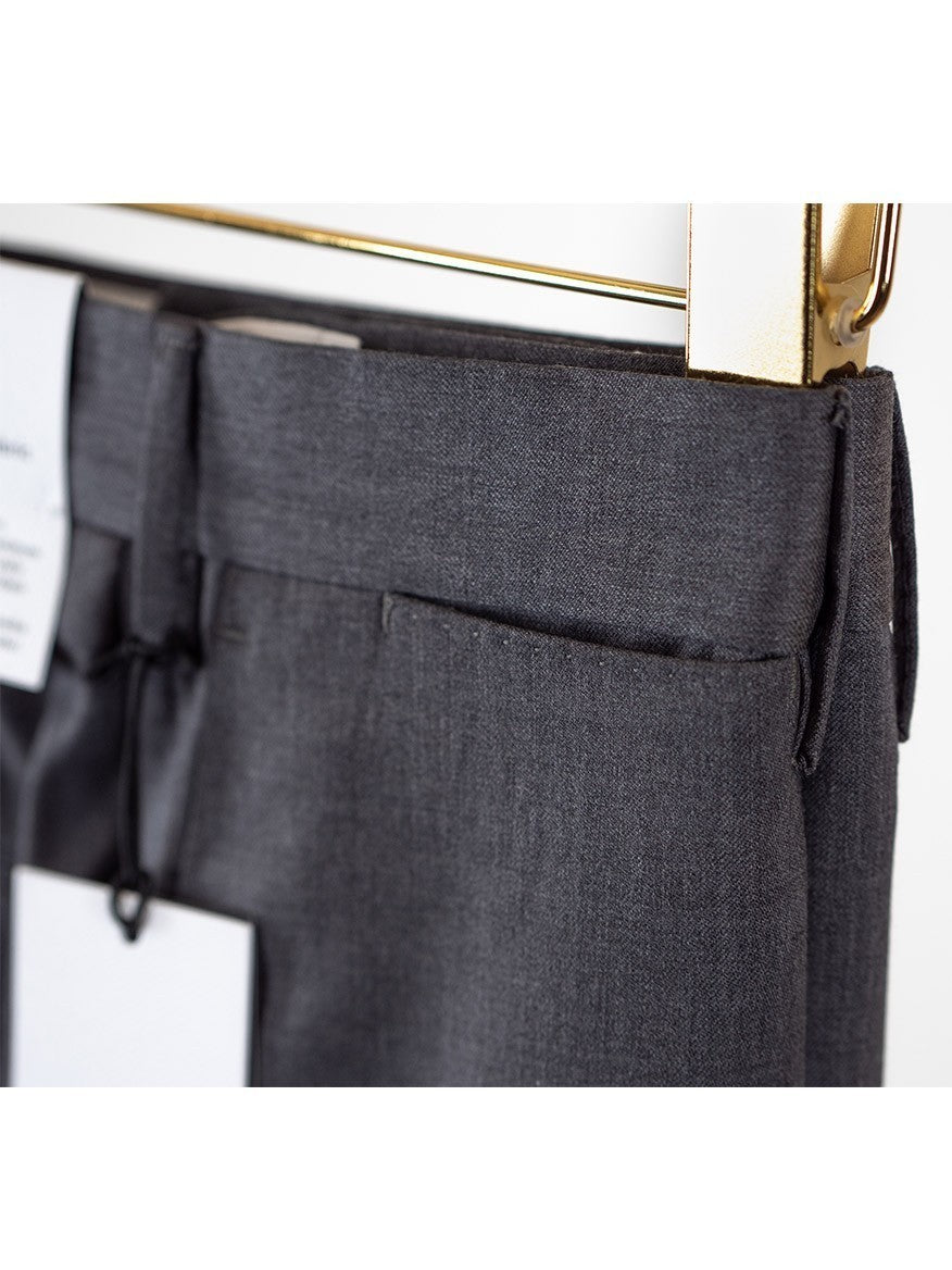 A close up of PT01 Estrato 120s Lux Wool Twill Trouser in Black with a gold tag.