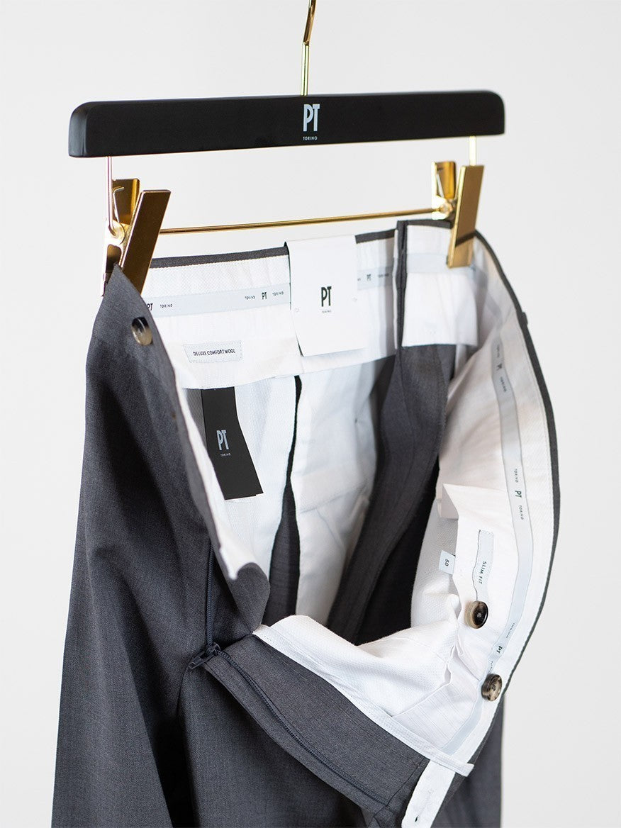 A pair of PT01 Estrato 120s Lux Wool Twill trousers hanging on a hanger, made from Italian natural stretch fabric.
