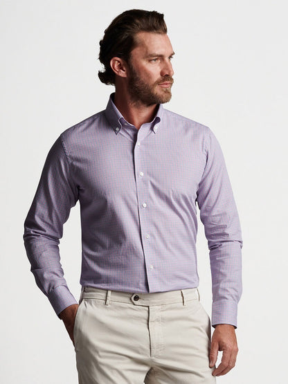 A man sporting a purple cotton Peter Millar Basie Sport Shirt in Rosewood paired with tan pants.