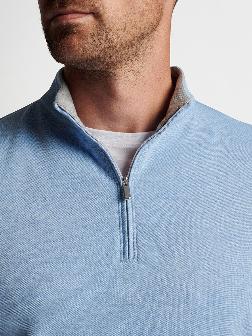 A man wearing a Peter Millar Crown Comfort Pullover in Cottage Blue quarter-zip sweater.