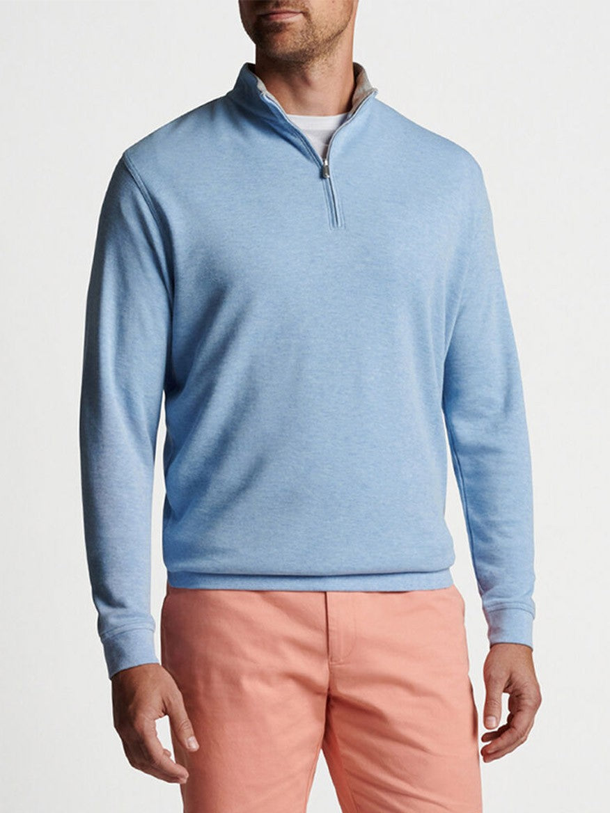 A man wearing a Peter Millar Crown Comfort Pullover in Cottage Blue quarter-zip sweater and pink pants.