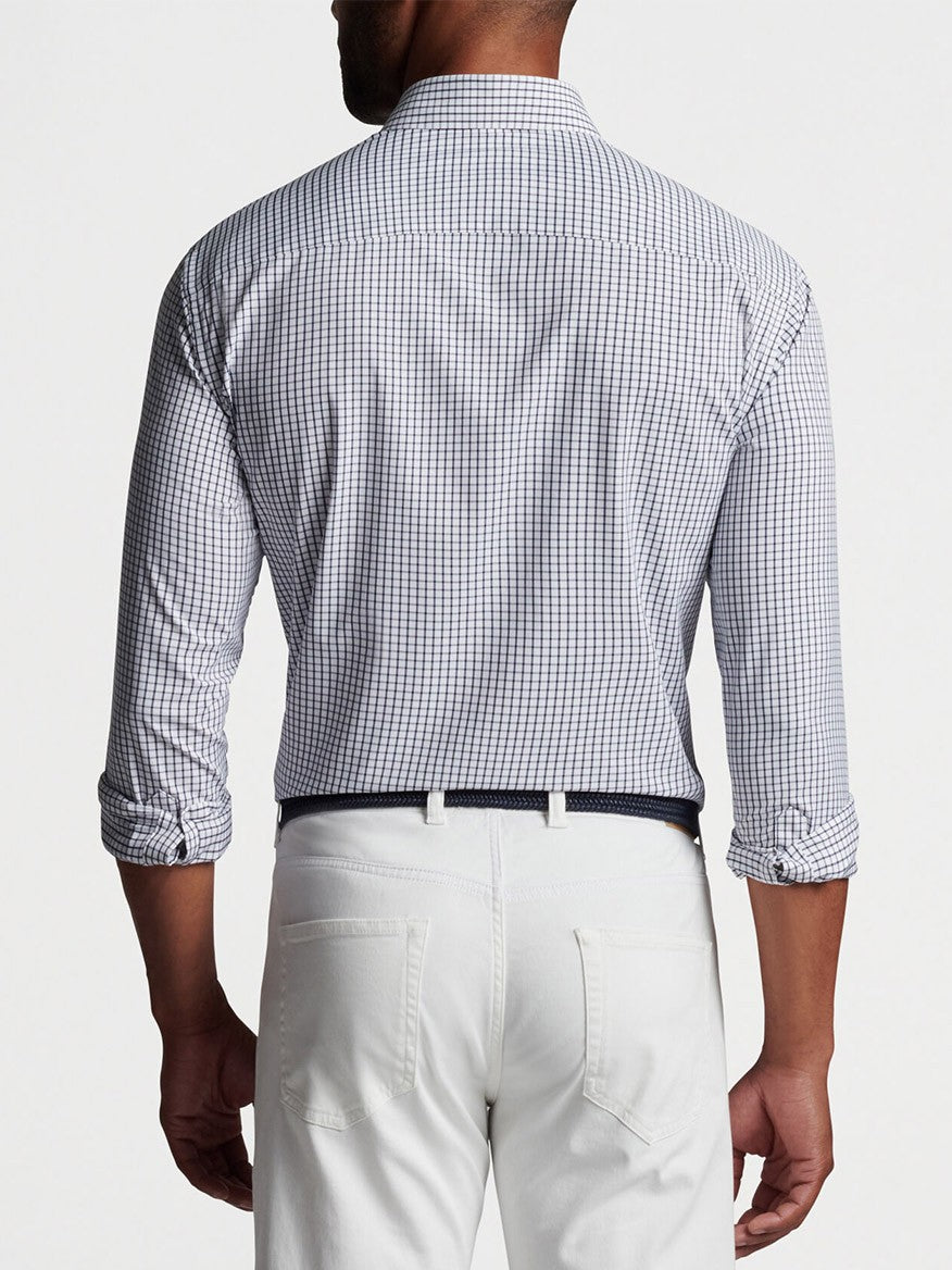 A man from behind wearing a Peter Millar Hanford Performance Twill Sport Shirt in Navy and white pants with a belt.