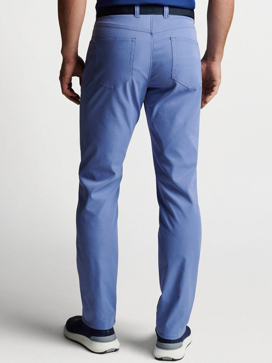 The Peter Millar eb66 Performance Five-Pocket Pant in Port Blue showcased the back view of a man donning blue pants.