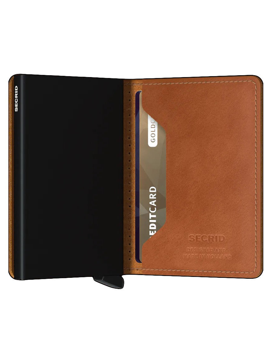 A black Secrid Slimwallet Perforated in Cognac open to show the cardholder section with a gold credit card inside, featuring RFID protection.