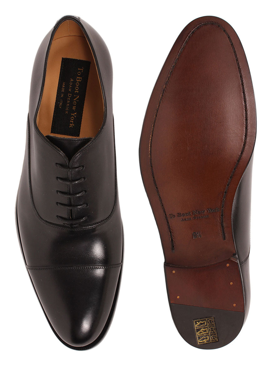 A pair of To Boot New York Forley in Nero calfskin leather dress shoes with a cap toe viewed from above.