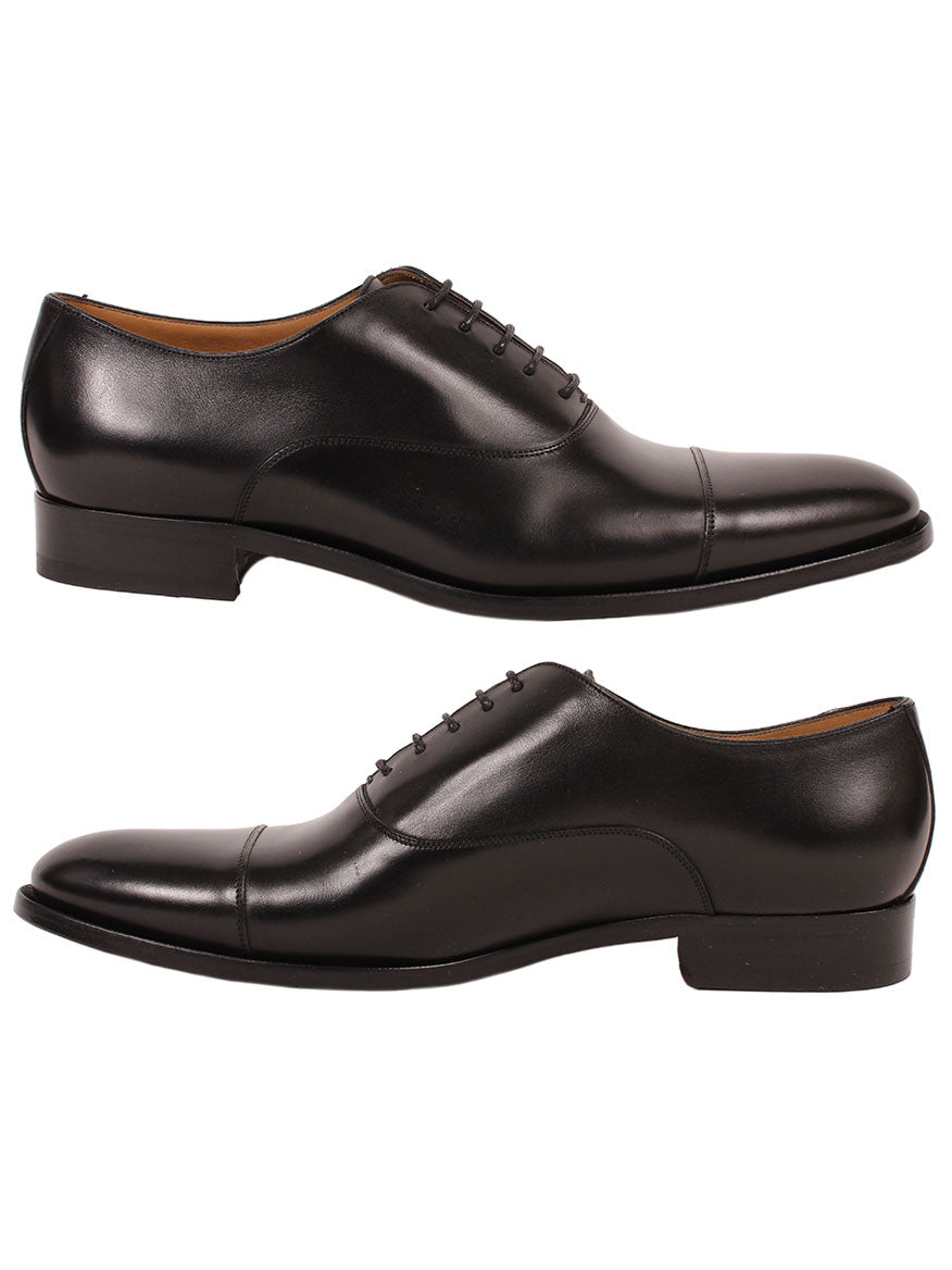 A pair of To Boot New York Forley in Nero calfskin leather oxford shoes with a cap toe against a white background.