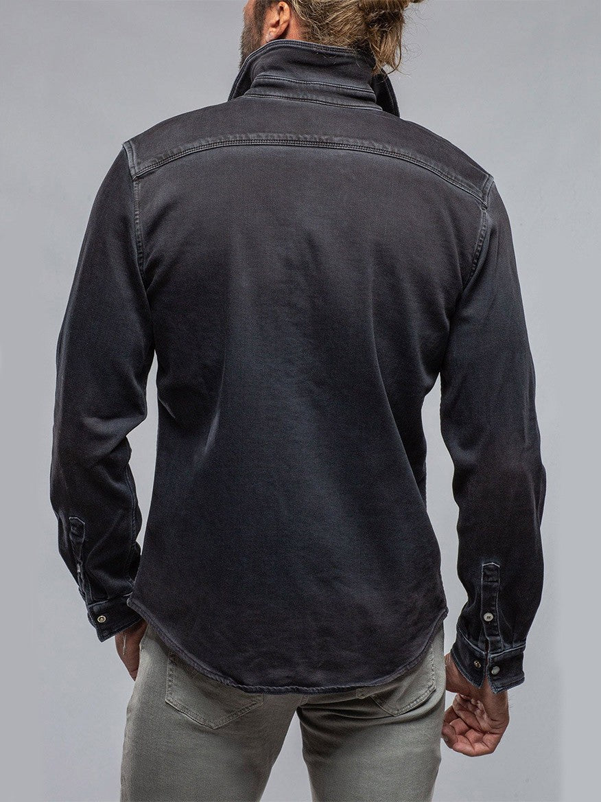 Back view of a person with a bun hairstyle wearing a Teleria Zed Roper Western Snap Shirt in Nero and olive pants.