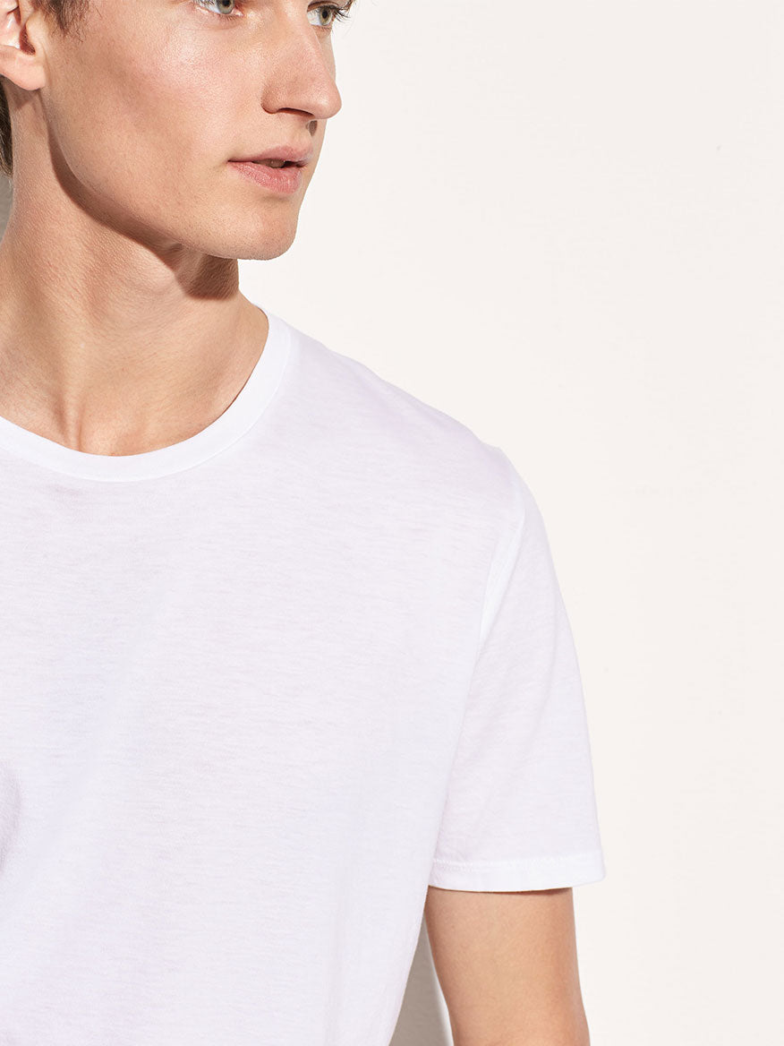 Side profile of a young man wearing a Vince Crew Neck T-Shirt in Optic White.