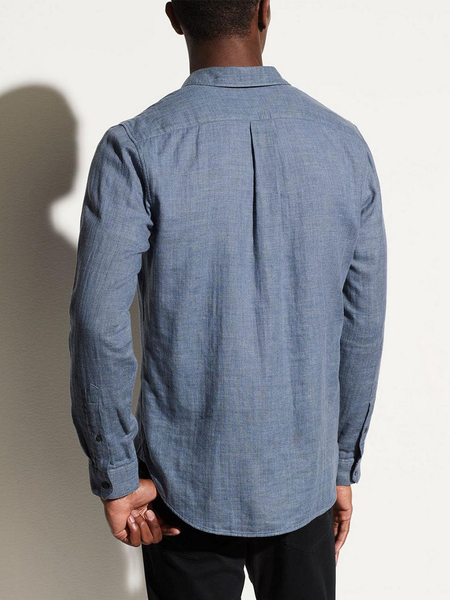 Man standing facing away from the camera, showcasing the back of a Vince Double Face Long Sleeve Sport Shirt in Chambray with a center pleat.