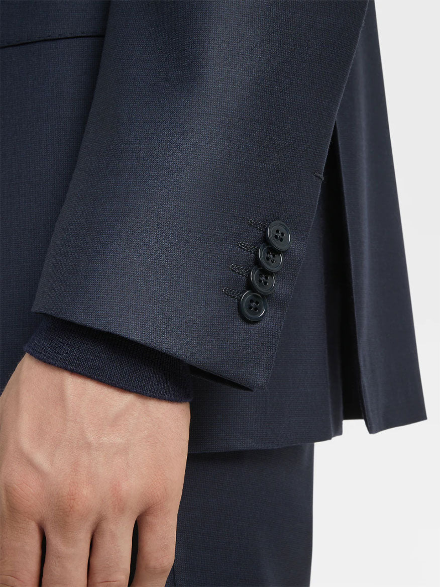 Close-up of a dark Zegna Navy Blue Milano Trofeo™ Wool Suit in Pinpoint Pattern jacket sleeve showing a row of buttons on the cuff.